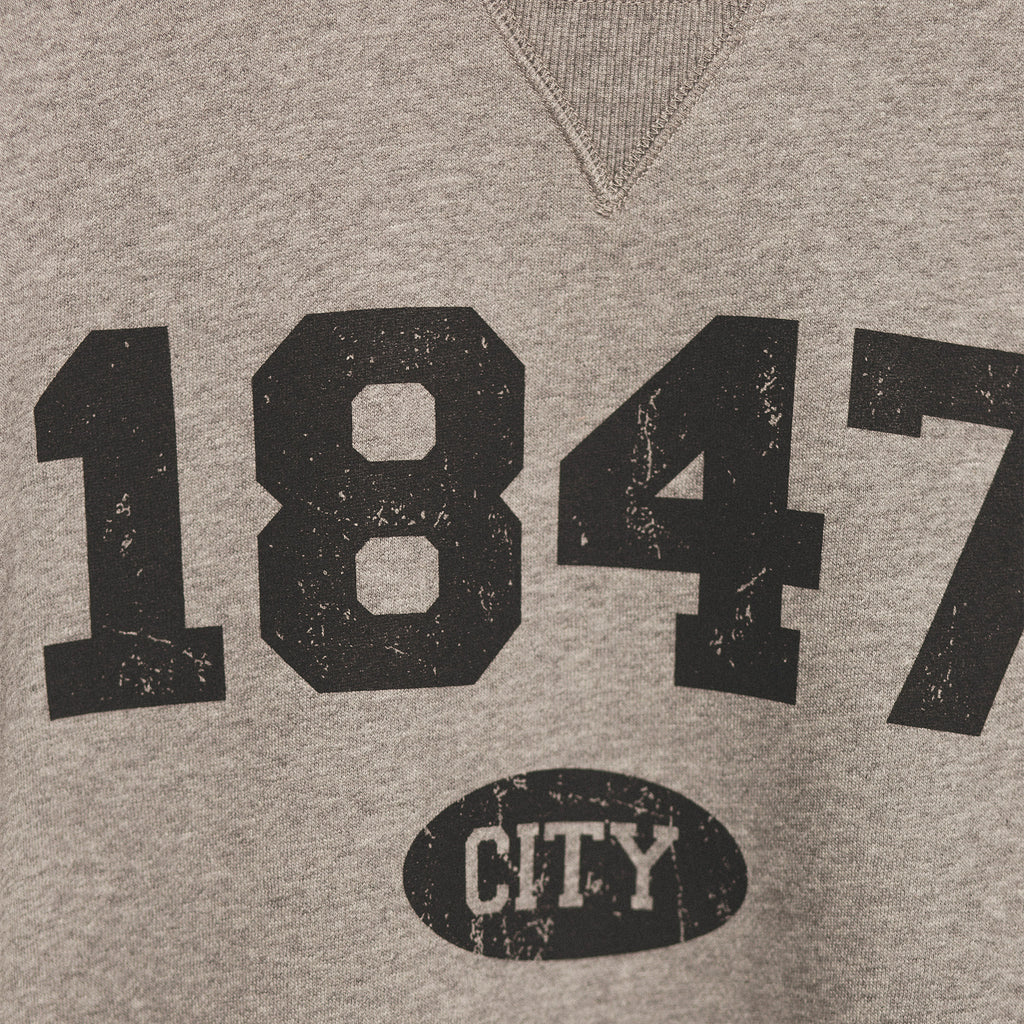 zoomed in image showcasing the screenprinted 1847 established year in black bold lettering with city in small bubble underneath