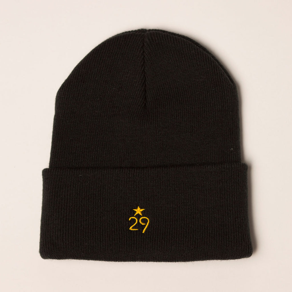 black beanie folding cuff with logo centered on back in gold