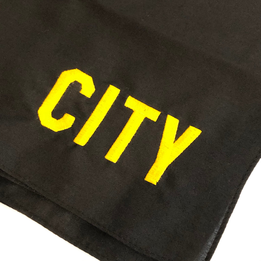closeup of city embroidered in gold in corner of black bandana