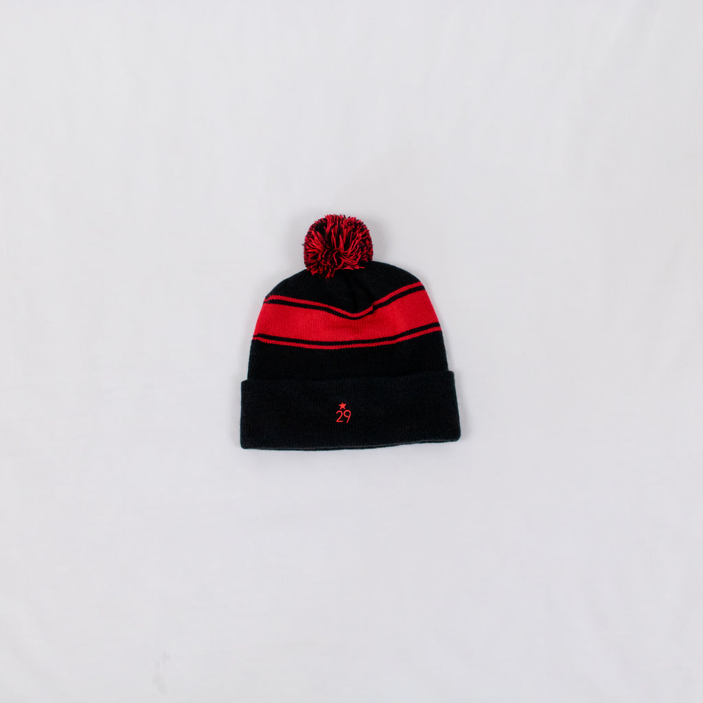black and red striped beanie with a two-tone pom on top 29th state apparel logo embroidered in red on back fold