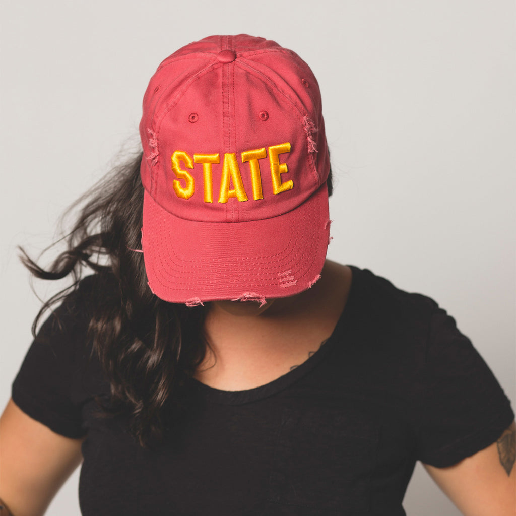 front view on model of red STATE Distressed Baseball Hat
