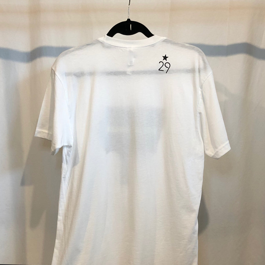 the back of an all white t-shirt on a hanger with the 29th state apparel logo in black on the right shoulder